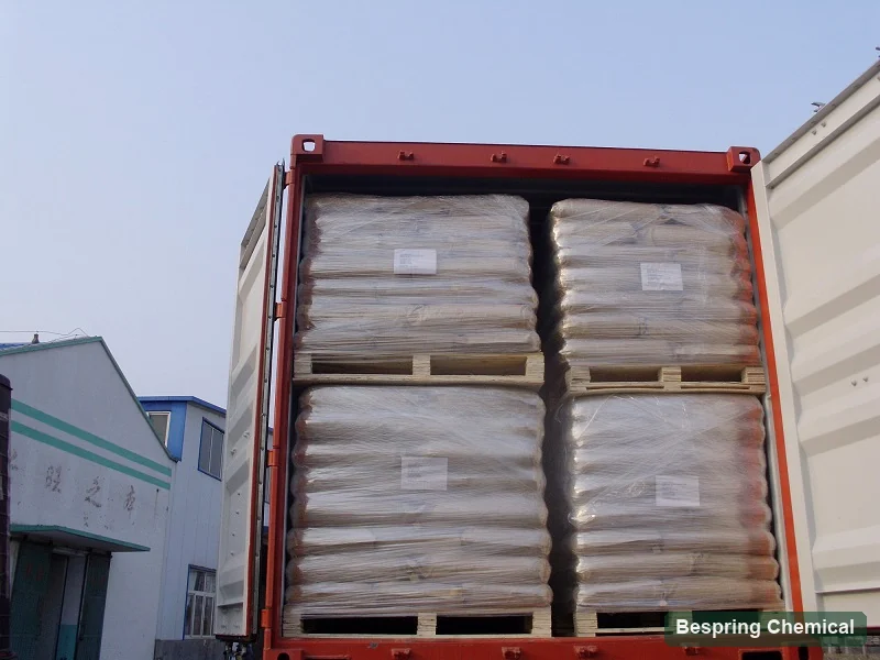 Wrapped paper bags stacked on pallets inside an open shipping container